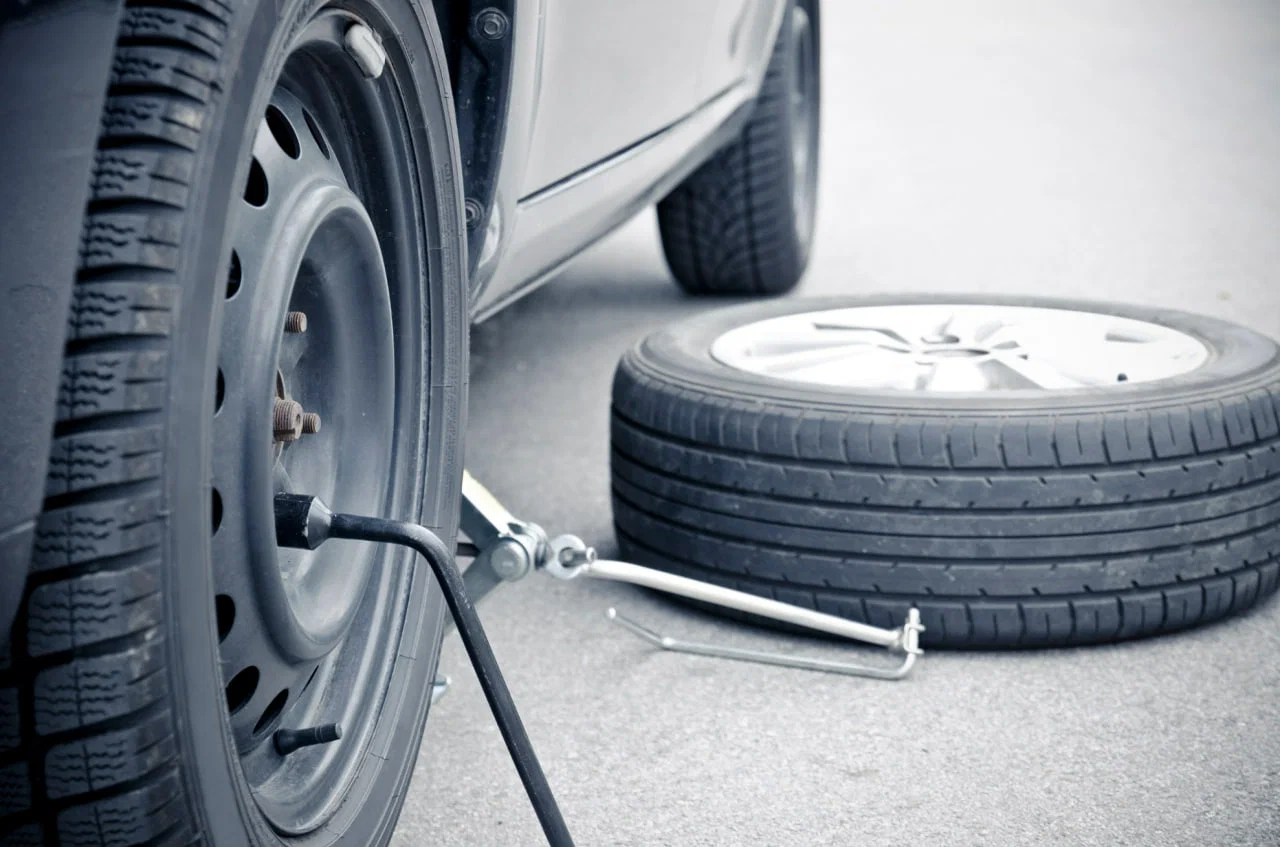 Fast Grip Mobile Tyres technician performing mobile tyre fitting on a car in Bristol streets.